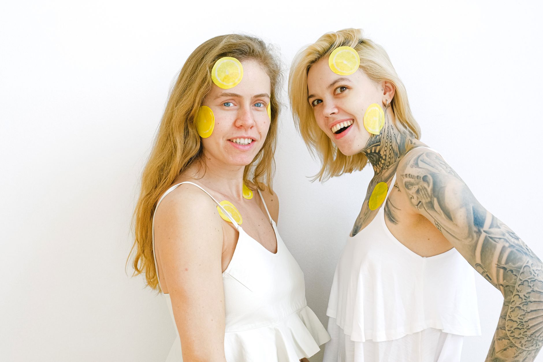 Fresh lemons on a white plate against a bright yellow background