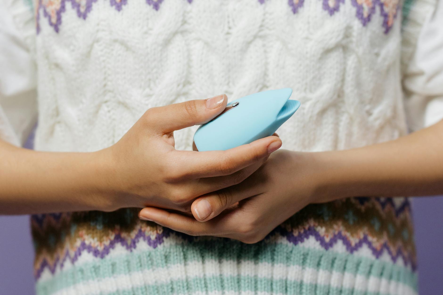Close-up of hands holding a personal massager, symbolizing self-care and reclaiming pleasure without shame