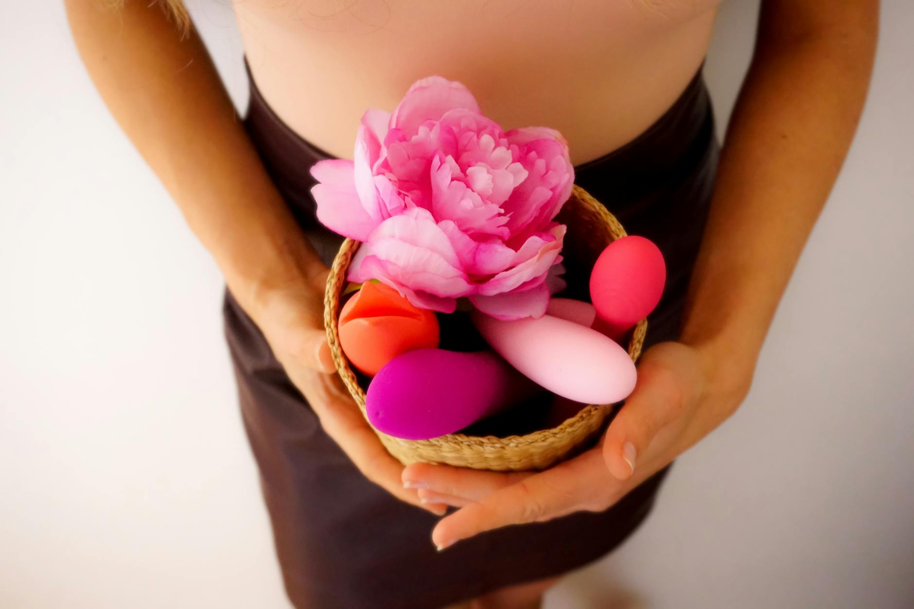 A yellow silicone vibrator surrounded by fresh produce on a bright yellow background